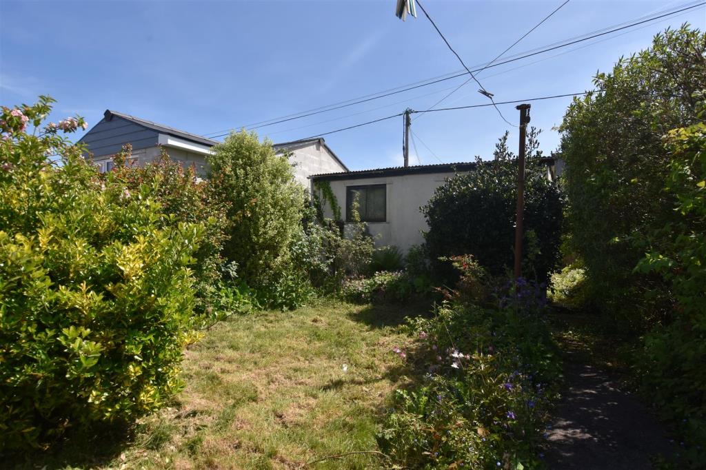 Lot: 34 - HOUSE FOR UPDATING WITH PARKING, GARDENS AND DETACHED GARAGE WITH POTENTIAL - Rear garden looking towards detached garage